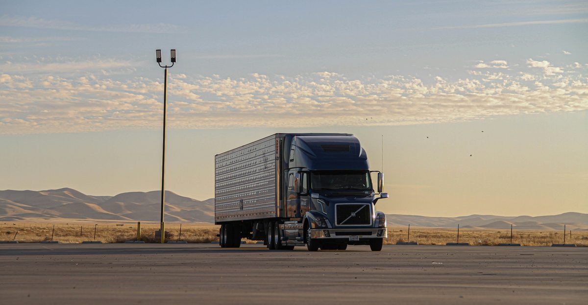 Blue Volvo semi truck at a depot